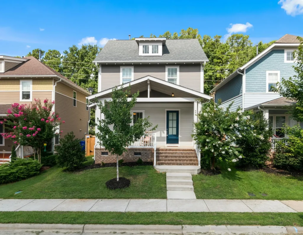 Restored two-story home with gray siding and a front porch