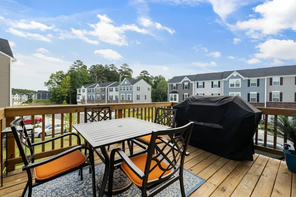 Finished wooden back deck with railing and outdoor furniture
