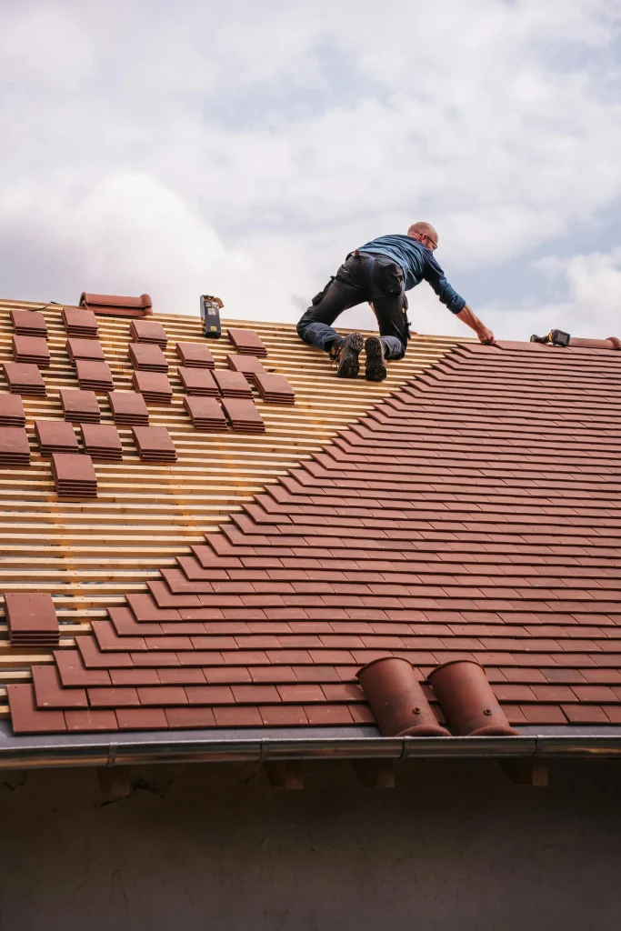 Roofer installing new shingles on a residential roof